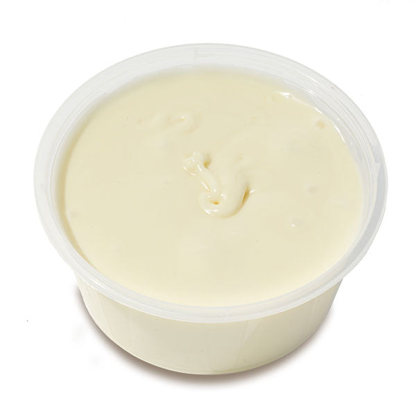 Container of white chocolate ganache on a white background
